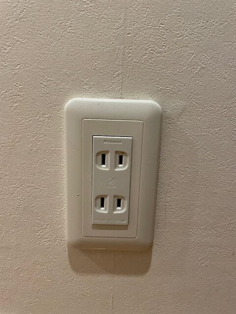 A typical wall outlet in Japan. There is no polarized prong nor earth. US plugs normally have no problem using a Japanese outlet.